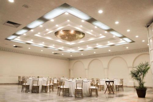 un salón de banquetes con mesas y sillas. en Radisson Hotel & Convention Center Toluca, en Toluca
