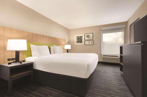 ein Hotelzimmer mit einem großen Bett und einem Fenster in der Unterkunft Country Inn & Suites by Radisson, Dunn, NC in Dunn
