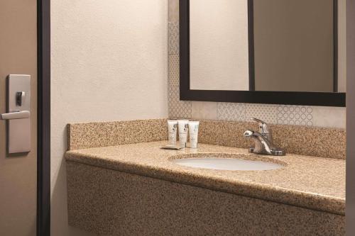 a bathroom counter with a sink and a mirror at Country Inn & Suites by Radisson, Dunn, NC in Dunn