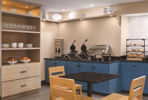 a kitchen with blue cabinets and a table with chairs at Country Inn & Suites by Radisson, Dunn, NC in Dunn