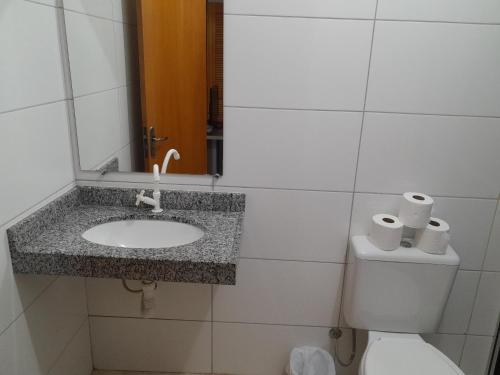 uma casa de banho com um lavatório, um WC e um espelho. em Hotel e Restaurante São Cristovão 