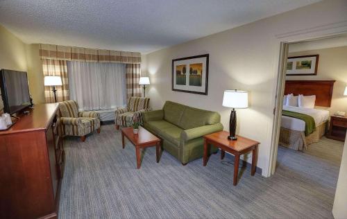 a hotel room with a couch and a bed at Country Inn & Suites by Radisson, Charlotte I-85 Airport, NC in Charlotte