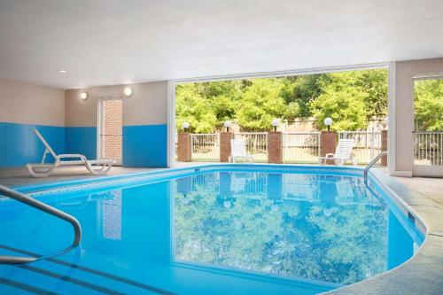 una piscina con acqua blu in una casa di Country Inn & Suites by Radisson, Charlotte University Place, NC a Charlotte
