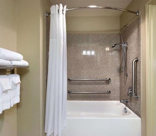 uma casa de banho com um chuveiro e uma banheira branca em Country Inn & Suites by Radisson, Concord (Kannapolis), NC em Concord