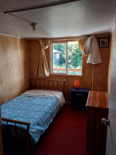 Habitación pequeña con cama y ventana en Departamento centro de Puerto Montt, en Puerto Montt