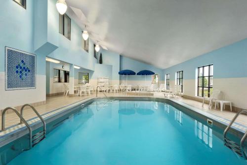 a swimming pool in a hotel with tables and chairs at Country Inn & Suites by Radisson, Fargo, ND in Fargo