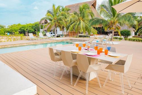 a dining table and chairs next to a swimming pool at U-GO Espectacular Casa en Barú con Vistas al Mar in Cartagena de Indias