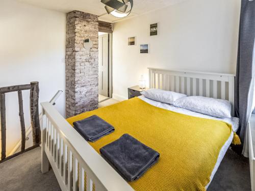 1 dormitorio con 1 cama con 2 toallas en The Cottage en Gorleston-on-Sea