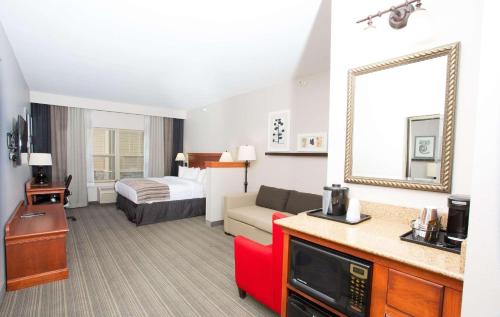 Habitación de hotel con sofá y cama en Country Inn & Suites by Radisson, Grand Forks, ND, en Grand Forks