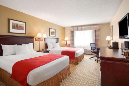 a hotel room with two beds and a television at Country Inn & Suites by Radisson, Lincoln North Hotel and Conference Center, NE in Lincoln