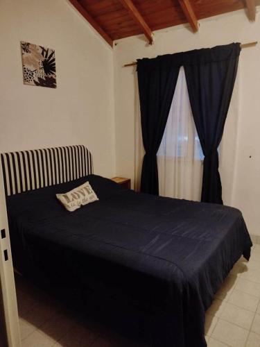 ein Schlafzimmer mit einem blauen Bett und einem Fenster in der Unterkunft Mirhouse1 in Puerto Madryn