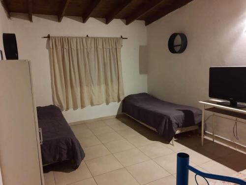 a bedroom with a bed and a desk with a television at Mirhouse1 in Puerto Madryn