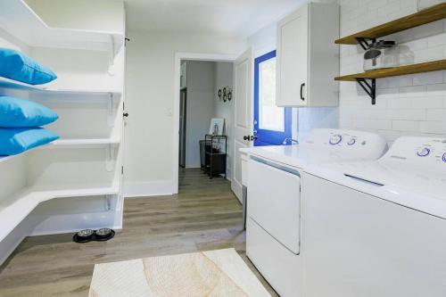 cocina blanca con armarios blancos y almohadas azules en Manchaca Meadows - 4 Bedroom Villa, en Manchaca