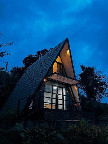 a small house with a pitched roof at night at A frame Riverston in Matale