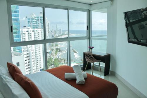 a bedroom with a bed with a view of the ocean at U-GO Edificio Murano Elite Bocagrande Frente al Mar in Cartagena de Indias