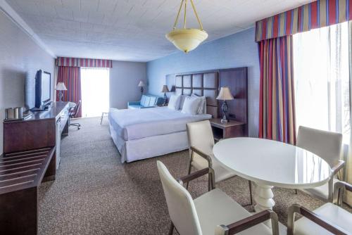 a hotel room with a bed and a table and chairs at Radisson Hotel Hauppauge-Long Island in Hauppauge