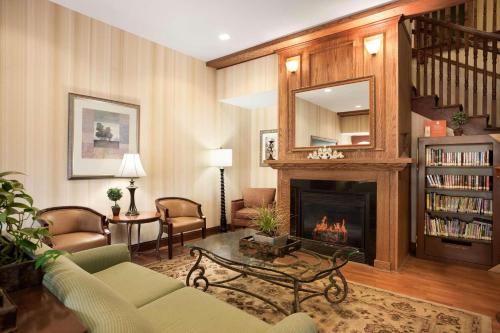 a living room with a fireplace and a couch at Country Inn & Suites by Radisson, Ithaca, NY in Ithaca