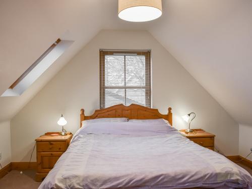 a bedroom with a bed and two night stands at Sycamore Cottage - Uk45923 in Ballater