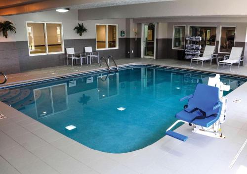費爾的住宿－南卡爾森費爾伯恩鄉村套房酒店，一个带蓝椅和椅子的大型游泳池