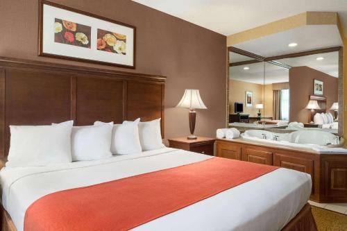 um quarto de hotel com uma cama e uma banheira em Country Inn & Suites by Radisson, Akron Cuyahoga Falls em Cuyahoga Falls