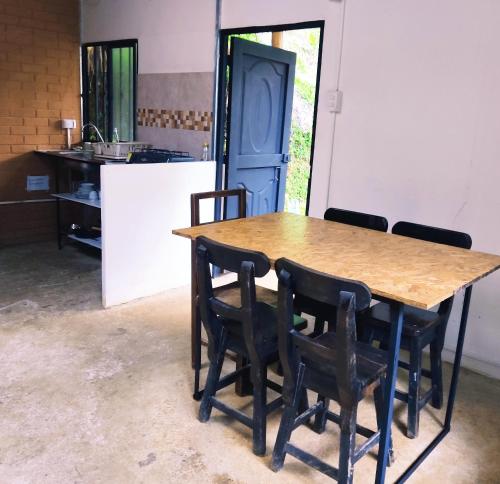 eine Küche mit einem Holztisch und schwarzen Stühlen in der Unterkunft Cucú Ardilla Vivienda Campestre en Pance in Cali
