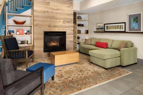 sala de estar con sofá y chimenea en Country Inn & Suites by Radisson, Columbus Airport, OH en Columbus