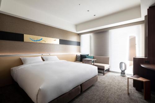 Cross Hotel Kyoto في كيوتو: سرير أبيض كبير في غرفة الفندق