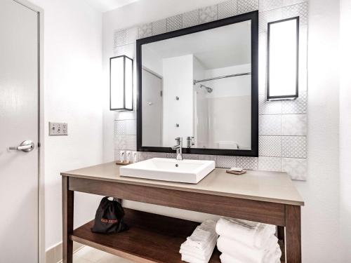 y baño con lavabo y espejo. en Country Inn & Suites by Radisson, Toledo, OH, en Maumee