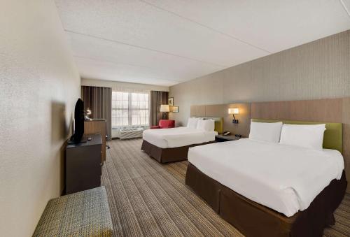 a hotel room with two beds and a television at Country Inn & Suites by Radisson, Findlay, OH in Findlay