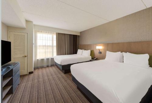 a hotel room with two beds and a television at Country Inn & Suites by Radisson, Findlay, OH in Findlay