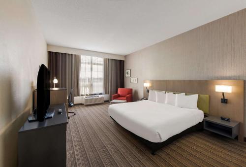 a hotel room with a large bed and a television at Country Inn & Suites by Radisson, Findlay, OH in Findlay