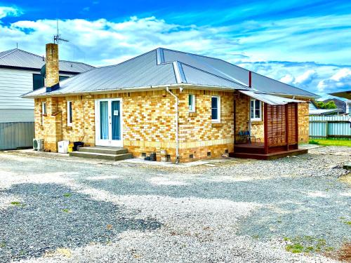 a brick house with a metal roof at D R Accommodation and Cozy Cabins, Hamilton East near to CBD and Waikato Hospital in Hamilton