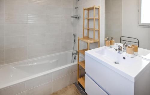 un bagno bianco con lavandino e vasca di Nice Home In Le Pontet With Kitchen ad Avignone