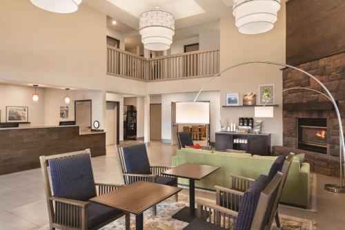un vestíbulo con mesas, sillas y chimenea en Country Inn & Suites by Radisson, Prineville, OR, en Prineville