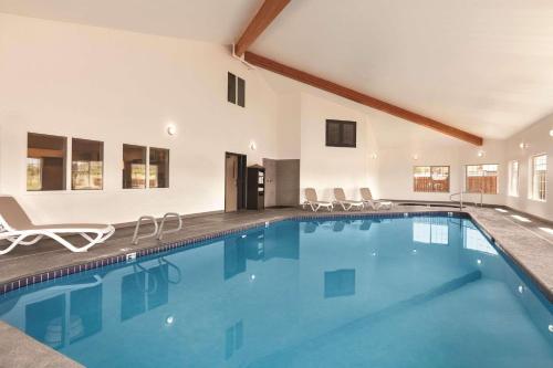 una gran piscina con sillas en una casa en Country Inn & Suites by Radisson, Prineville, OR, en Prineville