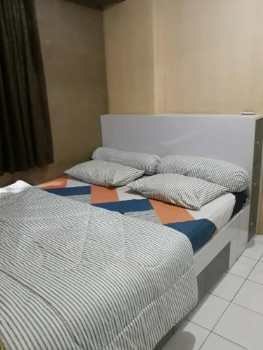 two twin beds in a room with at Kalibata city apartemen tower akasia in Jakarta