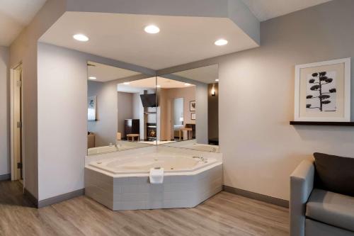 baño grande con bañera y espejo grande en Country Inn & Suites by Radisson, Harrisburg Northeast - Hershey, en Harrisburg