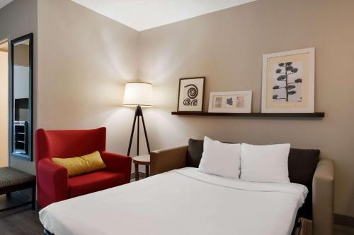 a hotel room with a bed and a red chair at Country Inn & Suites by Radisson, Harrisburg Northeast - Hershey in Harrisburg