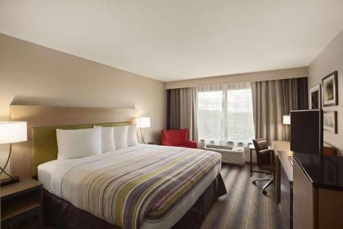 ein Hotelzimmer mit einem Bett und einem Fenster in der Unterkunft Country Inn & Suites by Radisson, Lewisburg, PA in Lewisburg