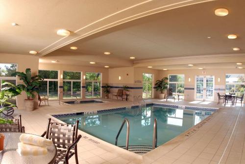 una grande piscina con tavoli e sedie in un edificio di Country Inn & Suites by Radisson, Lewisburg, PA a Lewisburg
