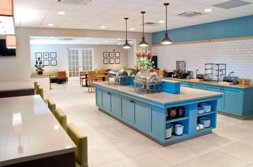 a cafeteria with blue cabinets and tables and chairs at Country Inn & Suites by Radisson, Lewisburg, PA in Lewisburg