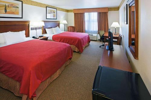 Cette chambre comprend deux lits et une télévision. dans l'établissement Country Inn & Suites by Radisson, Chambersburg, PA, à Chambersburg