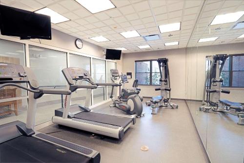 a gym with several tread machines and a tv at Country Inn & Suites by Radisson, State College Penn State Area , PA in State College