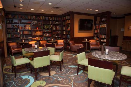 biblioteca con 2 mesas, sillas y estanterías en Radisson Hotel Philadelphia Northeast en Trevose