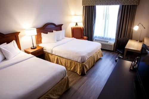 a hotel room with two beds and a window at Country Inn & Suites by Radisson, Harrisburg West Mechanicsburg in Mechanicsburg