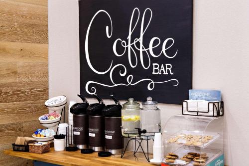 a counter with a coffee bar sign on a wall at Country Inn & Suites by Radisson, Harrisburg West Mechanicsburg in Mechanicsburg