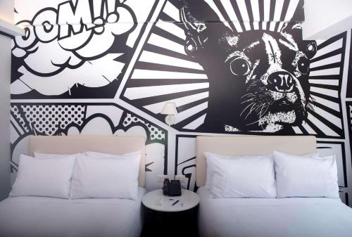 a bedroom with two beds and a mural of a dog at Radisson RED Miraflores in Lima