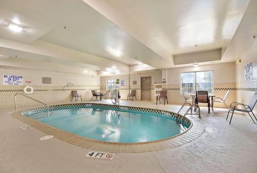 uma grande piscina numa sala com mesas e cadeiras em Country Inn & Suites By Radisson, Charleston North, SC em Charleston