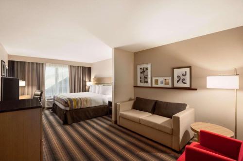 Habitación de hotel con cama y sofá en Country Inn & Suites by Radisson, Rock Hill, SC, en Rock Hill