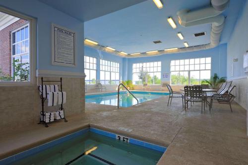 a pool with a table and chairs next to a swimming pool at Country Inn & Suites by Radisson, Orangeburg, SC in Orangeburg